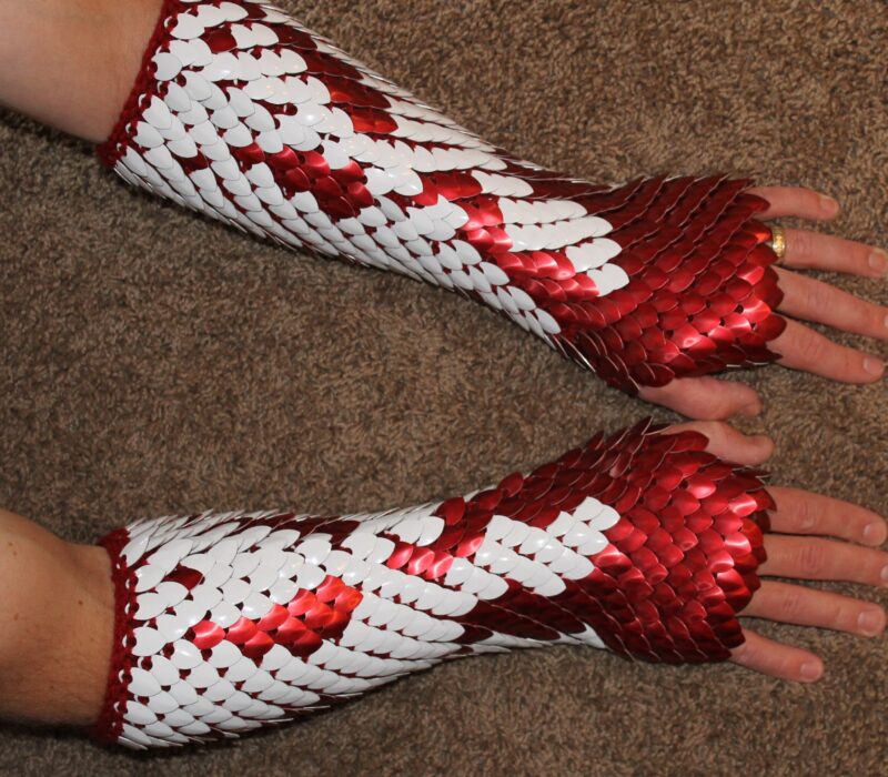 Red and white long scalemaille gauntlets on red yarn