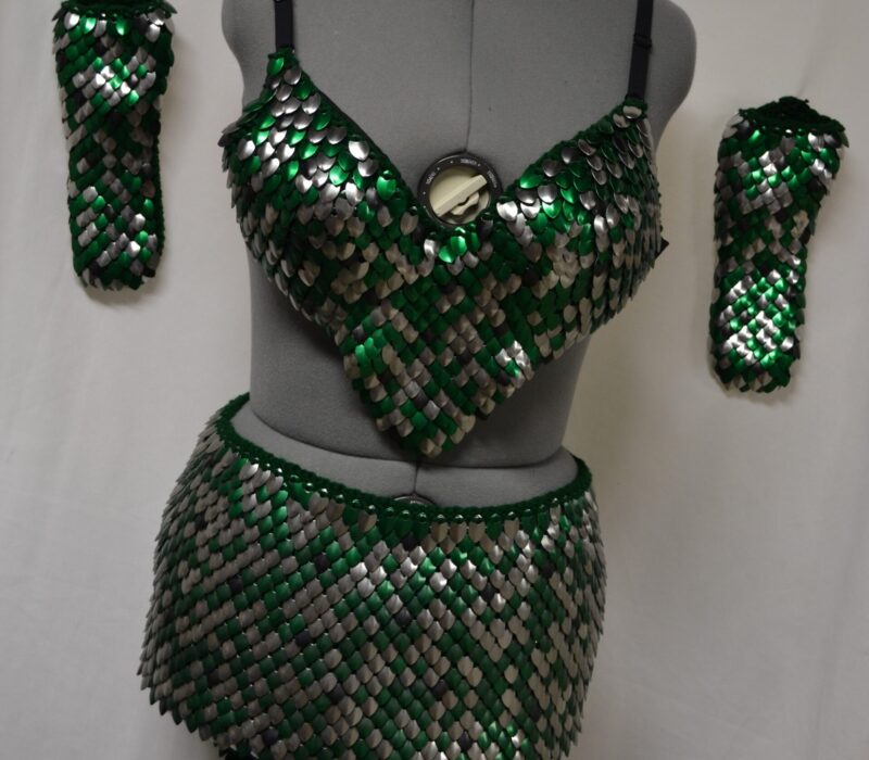 A matching set of knitted dragonhide in green and silver - two gaubtlets, a bra top, a skirt, and a collar.