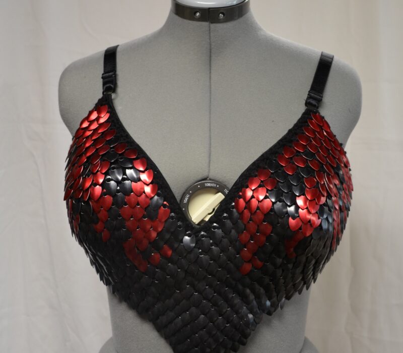 A knitted scalemaille bra top in red and black.