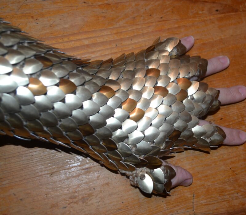 SIlver and bronze knitted dragonhide gauntlets with cut off fingers.